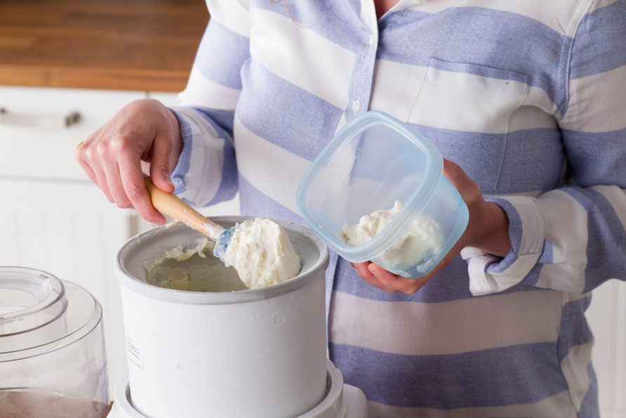Now finished, the frozen yogurt is being removed from the ice maker and put into tuberware