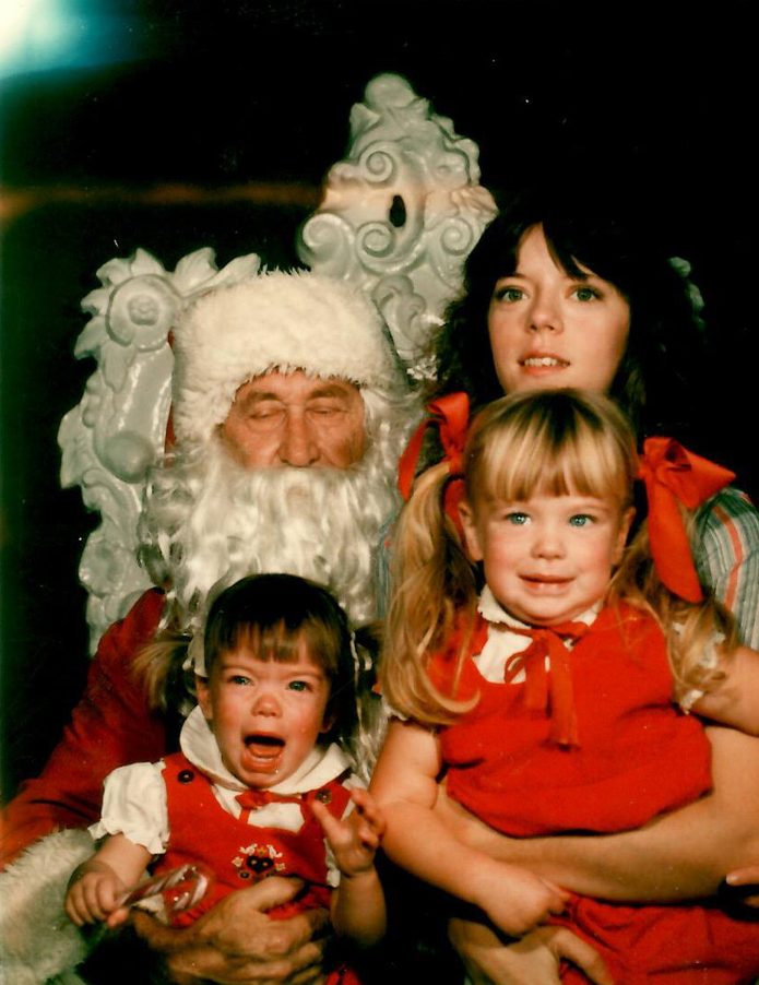 Mother and her two kids posing next to Santa