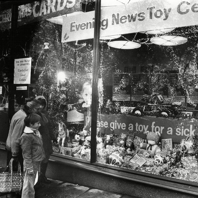 Shoppers Look In Store Window Display For Evening News