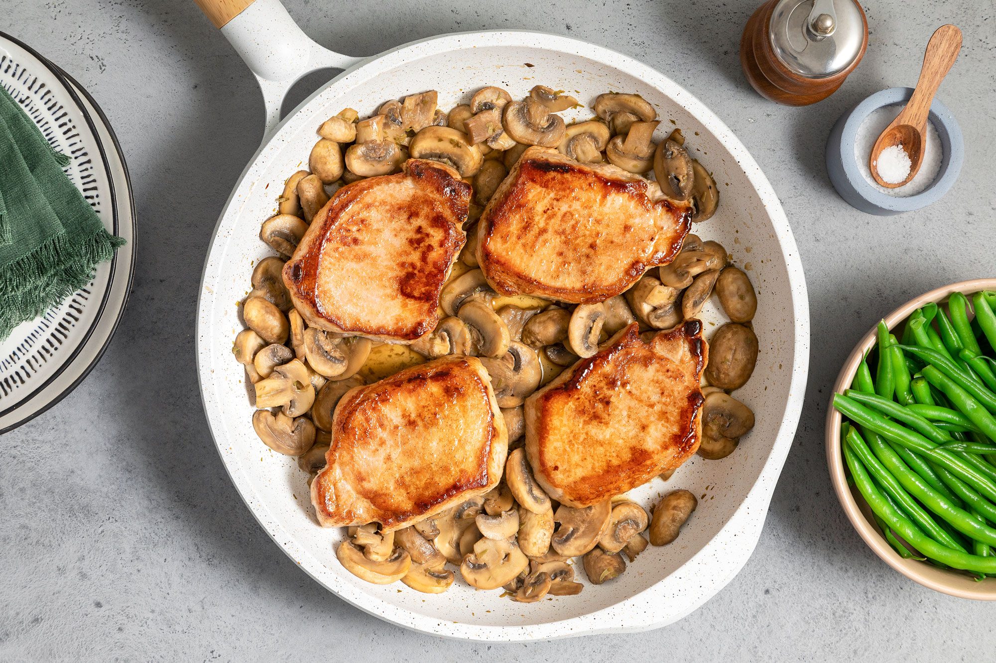 Mushroom Pork Chops in A White Non Stick Skillet