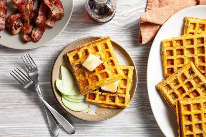 Sweet Potato Waffles topped with Butter and sliced apples and bacon on the side