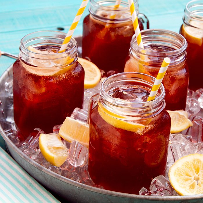 Mason jar mugs filled with iced tea and fresh lemon