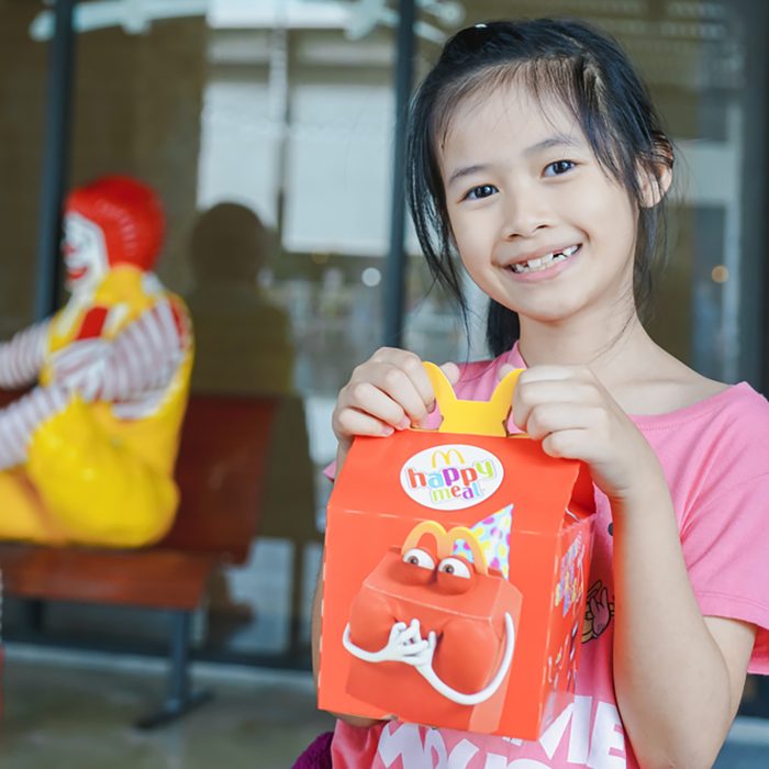BANGKOK,THAILAND - MARCH 10,2018 :little Asian girl holding happy meal box at McDonald