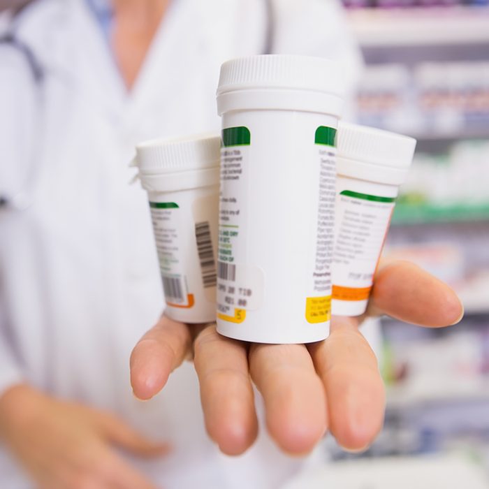 Pharmacist presenting medications on her hand in the pharmacy
