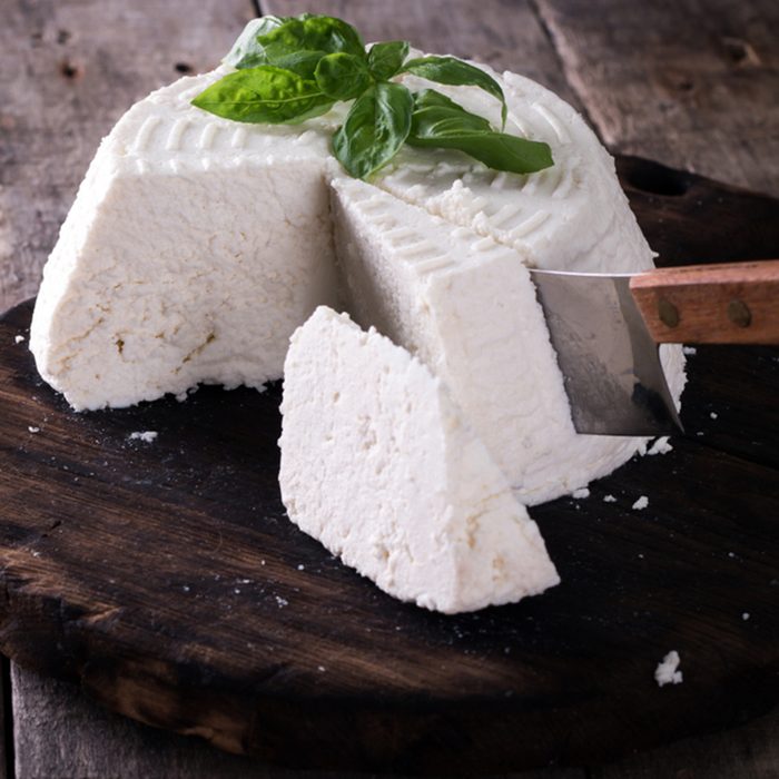 A fresh ricotta with basil leaf on wooden table italian food concept
