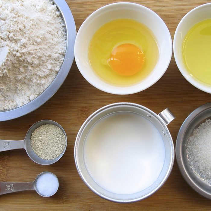 Materials of milk bread -- flour, egg, melted butter, yeast, salt, sugar and milk.