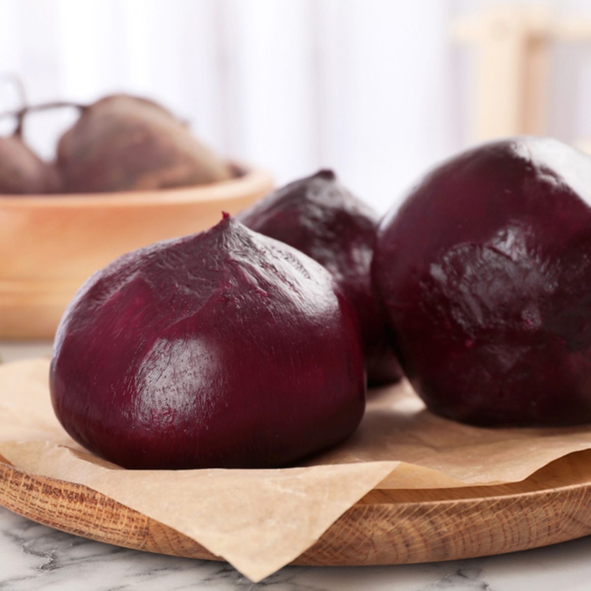 Plate with ripe peeled beets on table
