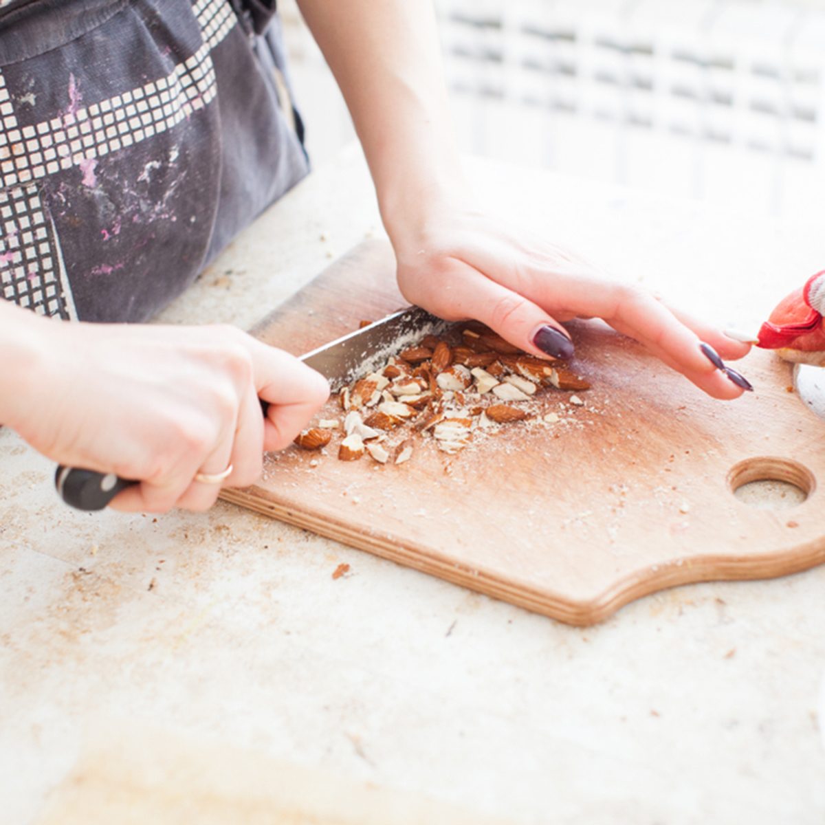 The concept of cooking. The confectioner cuts the almonds for the cake.; Shutterstock ID 1059938054; Job (TFH, TOH, RD, BNB, CWM, CM): Taste of Home