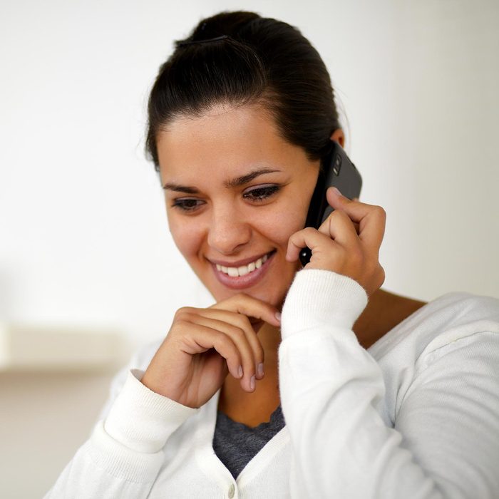 Pretty young woman conversing on cellphone