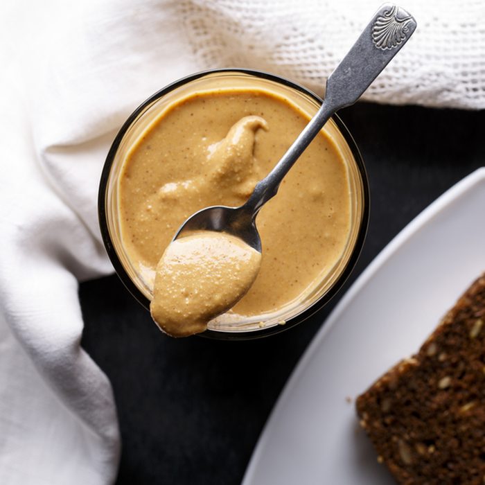 Homemade organic peanut butter, only crushed peanuts inside. Top view.; Shutterstock ID 754716562