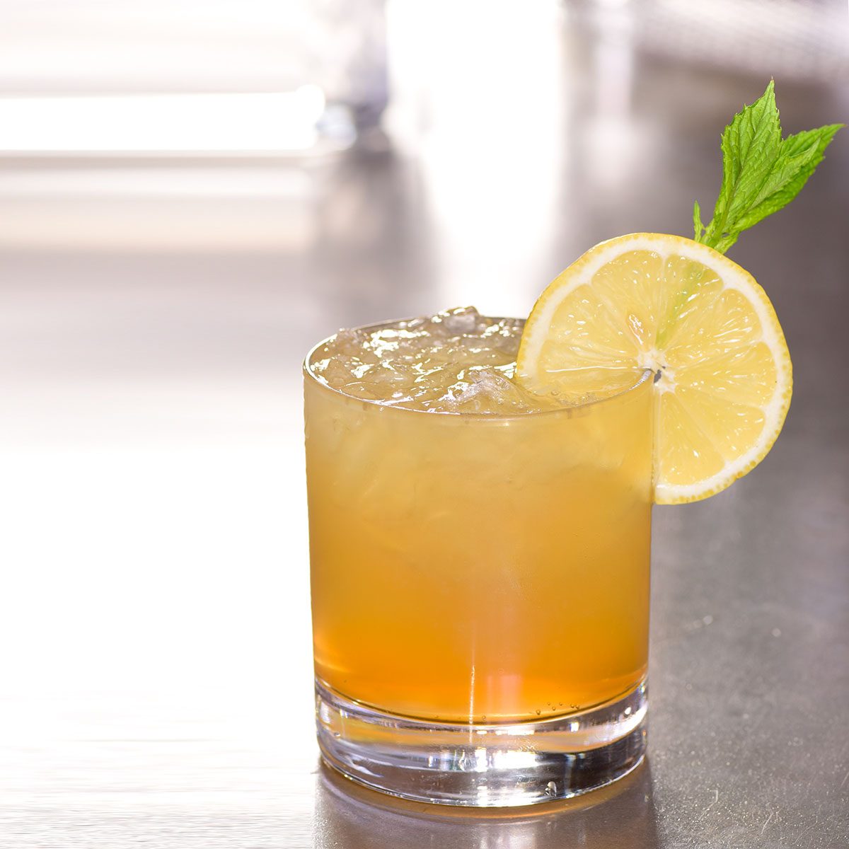 whiskey lemonade sour based cocktail drink decorated lemon mint on bar counter