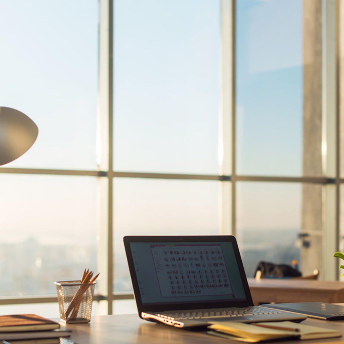 Side view picture of studio workplace with blank notebook, laptop.