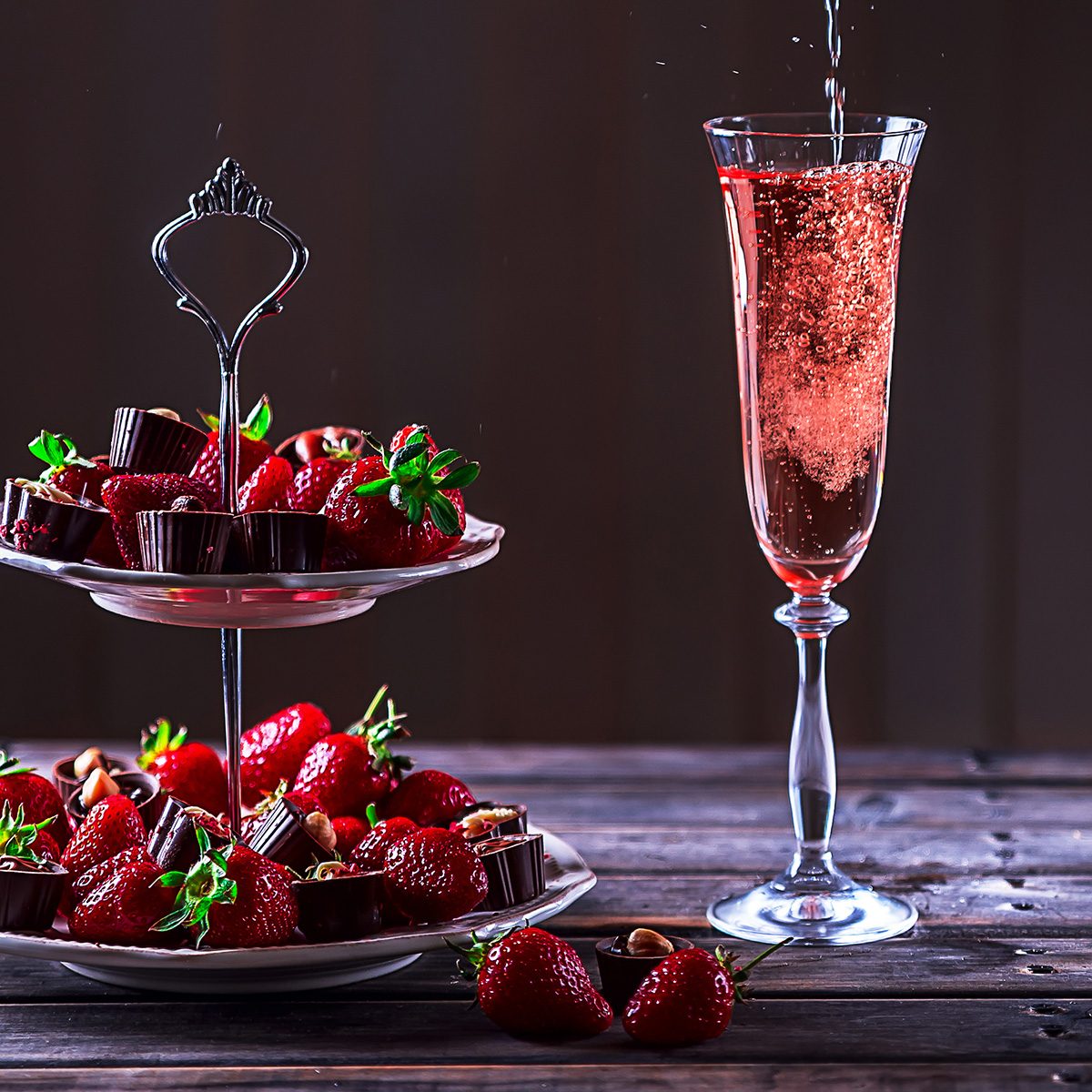 Sparkling pink wine is poured in glass.