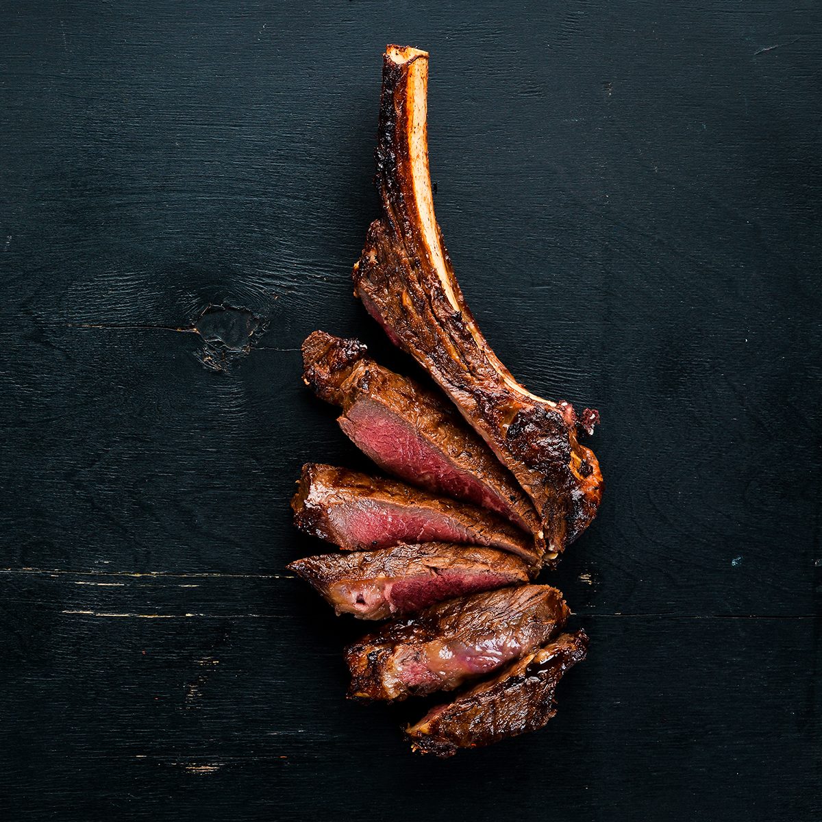 Steak on the bone. tomahawk steak On a black wooden background.