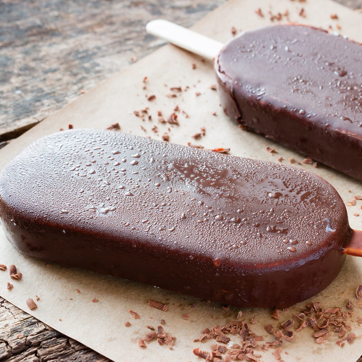 popsicle with grated chocolate on a wooden background