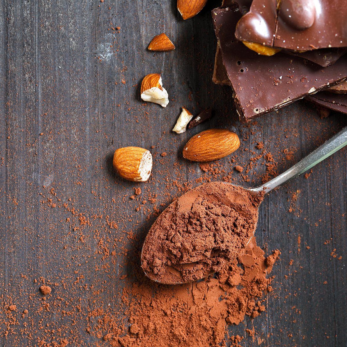 Cocoa Powder and Dark Chocolate almond on black wood table