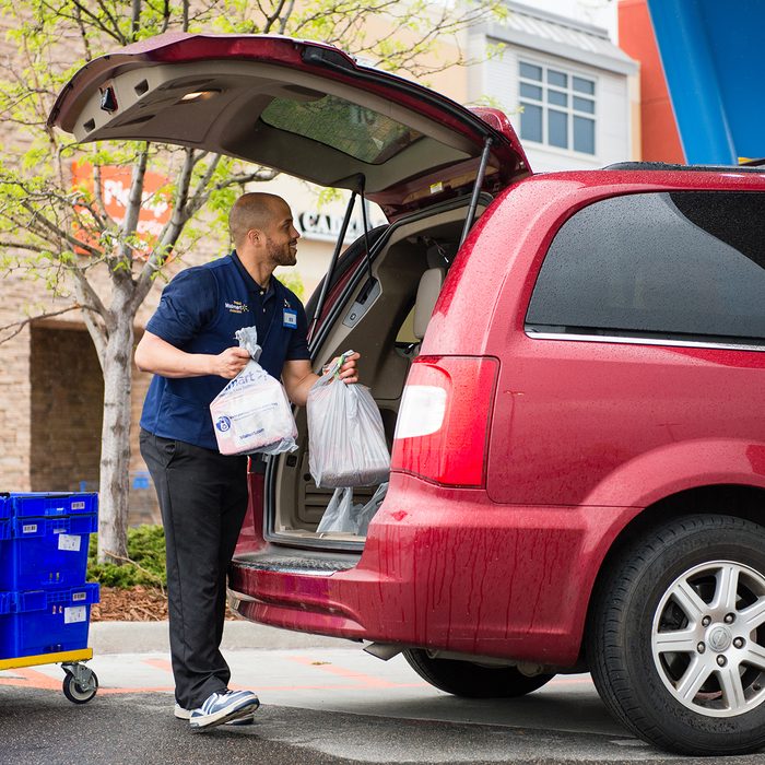 Walmart employee putting groceries into a customer