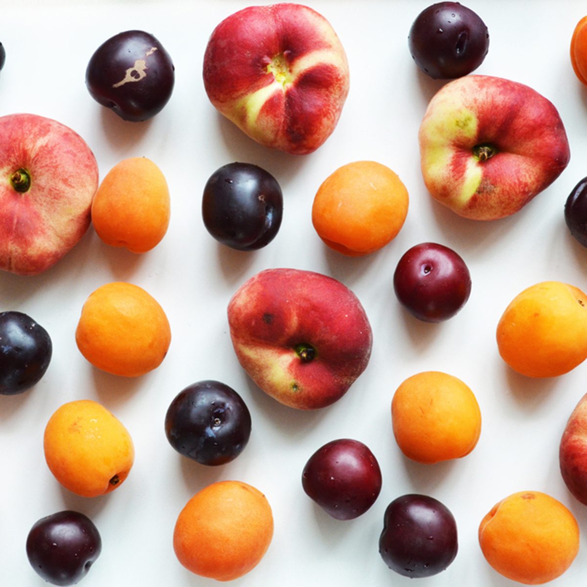Delicious ripe summer fruits on a white background. Composition of peaches, plums, apricots. View from above.; Shutterstock ID 675469345