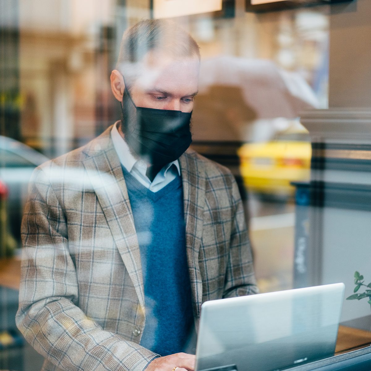 Businessman in cafe is wearing mask for protection against coronavirus