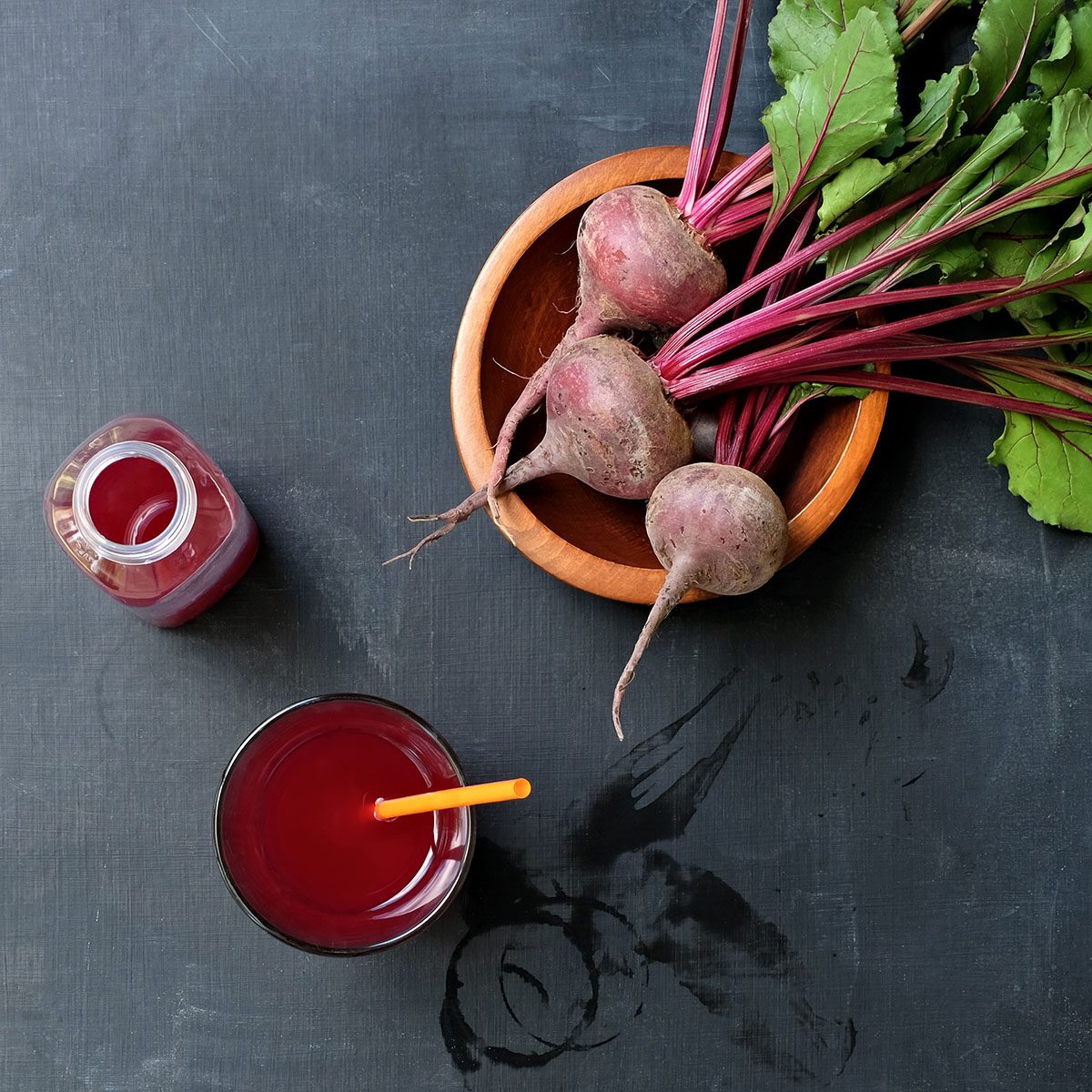 Healthy Beet Juice and Kombucha Drink on Messy Black Slate Table with Fresh Beets in Bowl