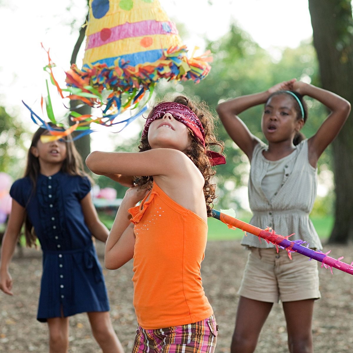 Girl at birthday party hitting pinata