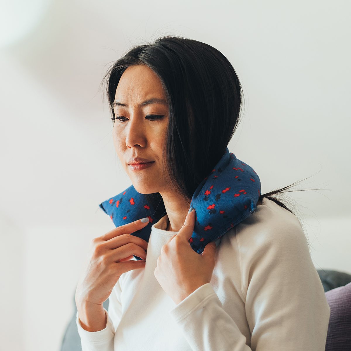 Young Asian woman feeling sick with flu, fever and headache while at home.