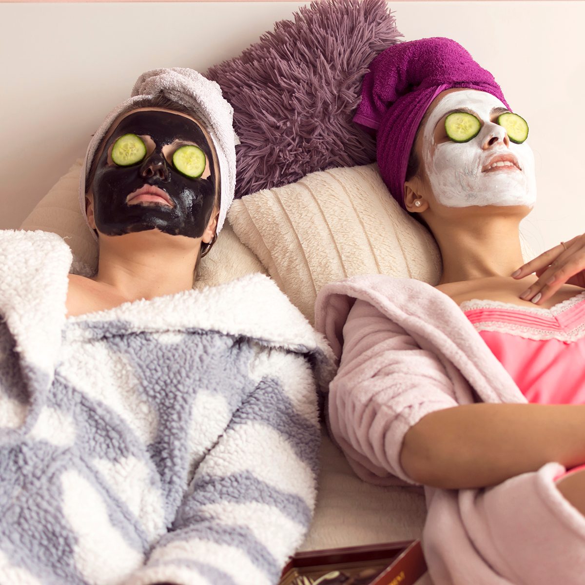 Two young girlfriends making facial mask at home