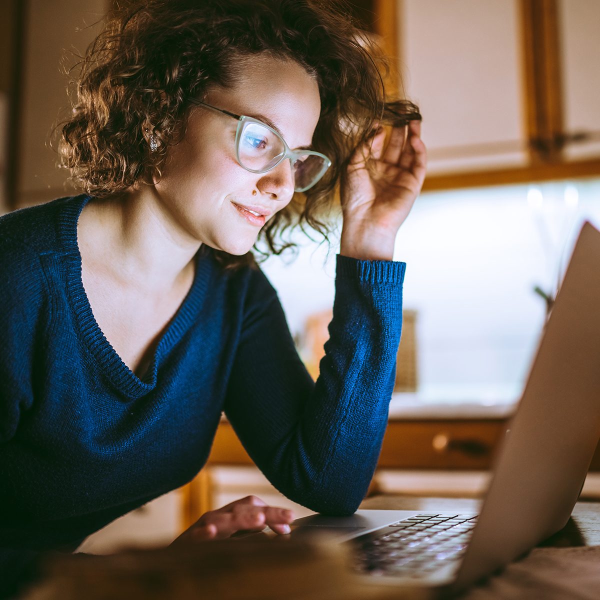 Young beautiful woman looking at the screen of a laptop and smiling