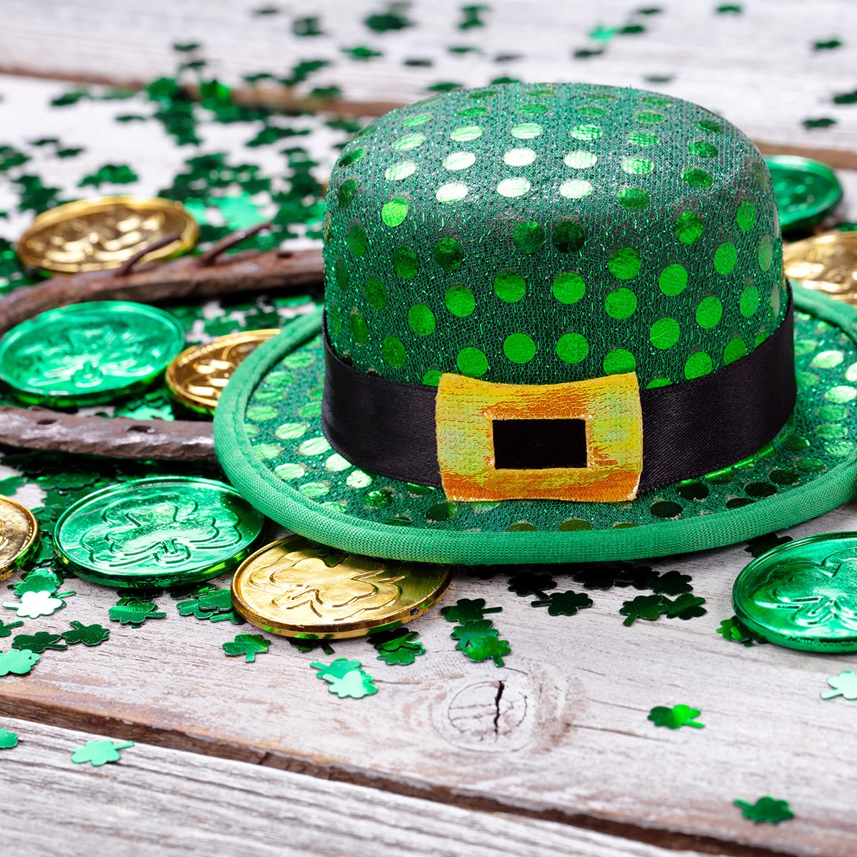 Close Up Of Coins With Horseshoe And Hat On Wooden Table