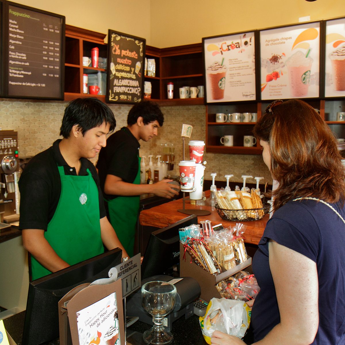 Woman Customer At Counter Ordering Food And Drink In Starbucks Coffee, Avenida Pedro D