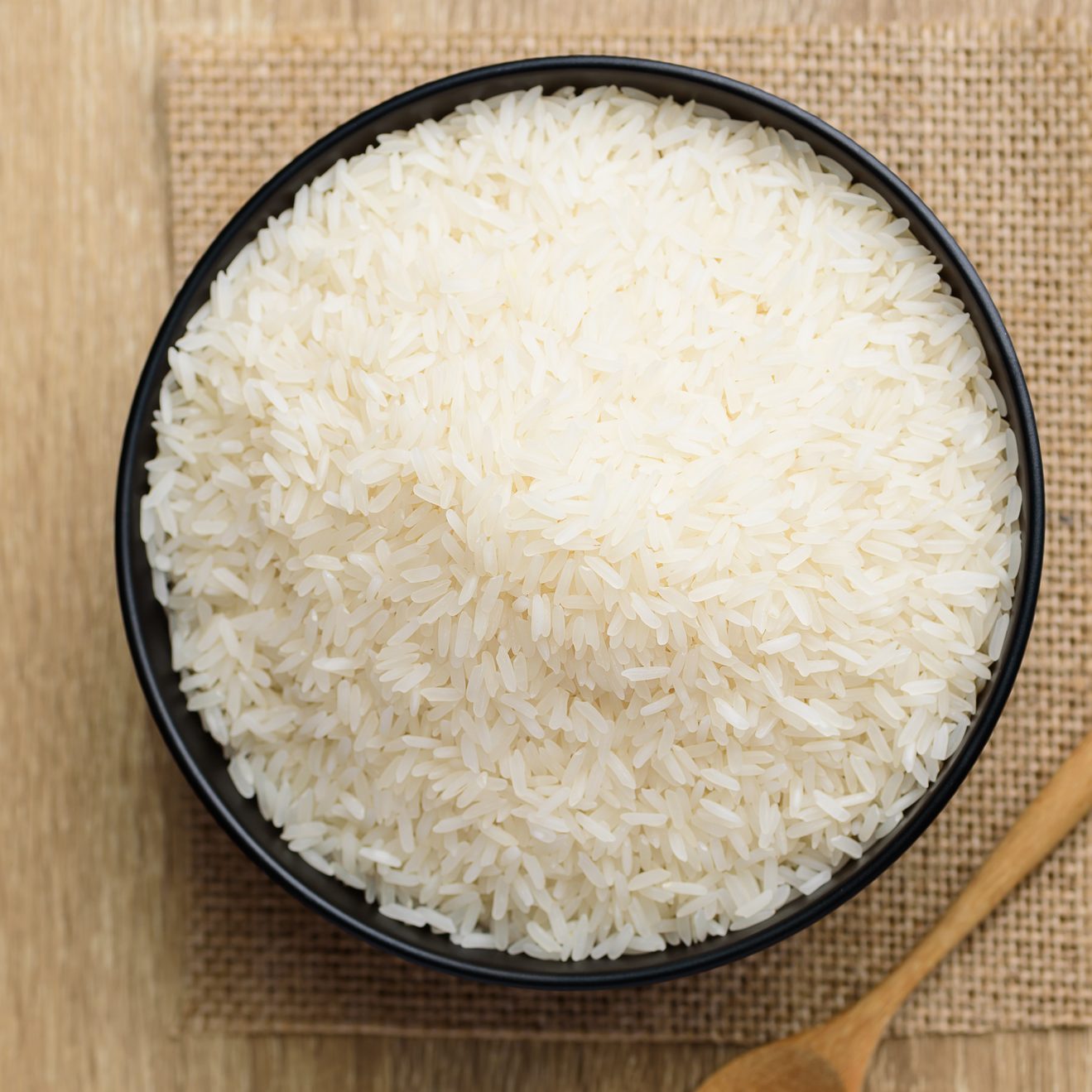 Organic Thai Jasmine rice grain in bowl on wood table