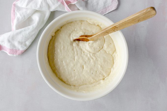 pancake mix in a bowl and a wooden spoon, view from above