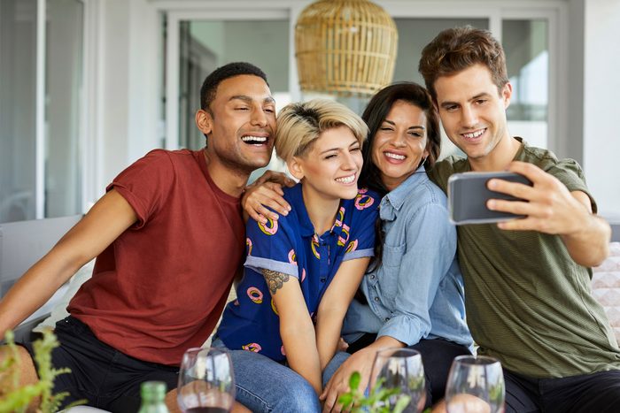 Happy friends taking selfie in backyard