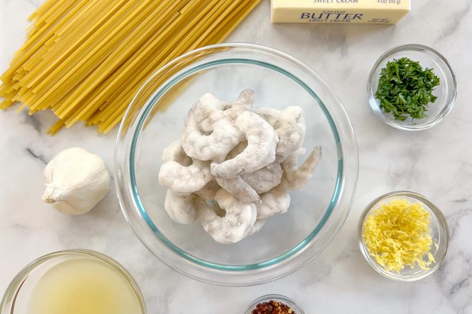 kitchen counter with raw ingredients for making shrimp scampi