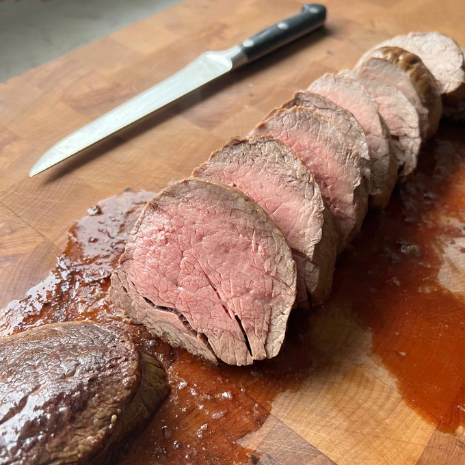 Ina Garten Beef Tenderloin cut up on a cutting board