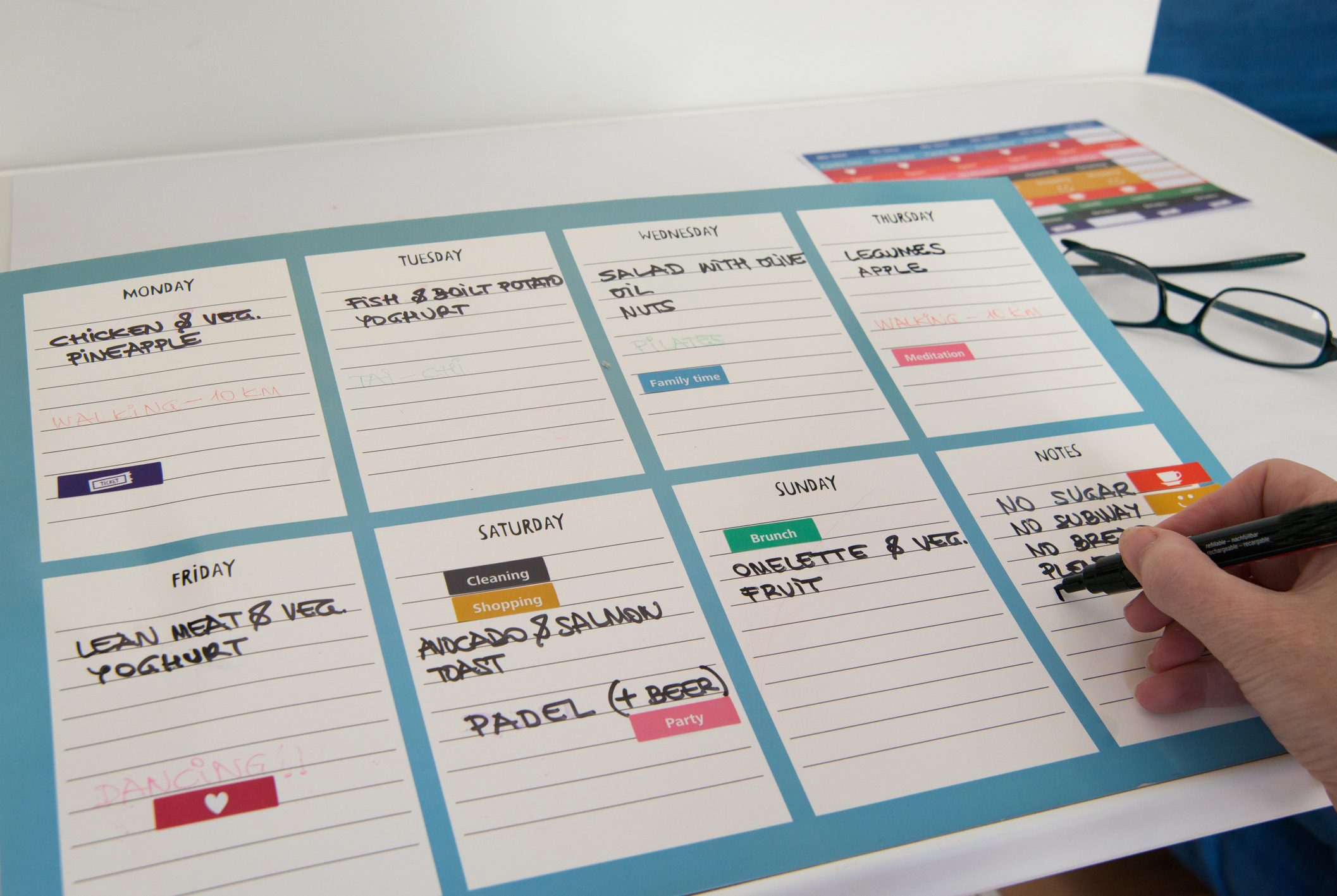 Hand writing weekly schedule for healthy life