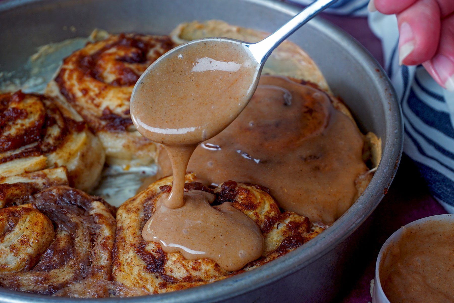 Drizzling spice mix on cinnamon rolls