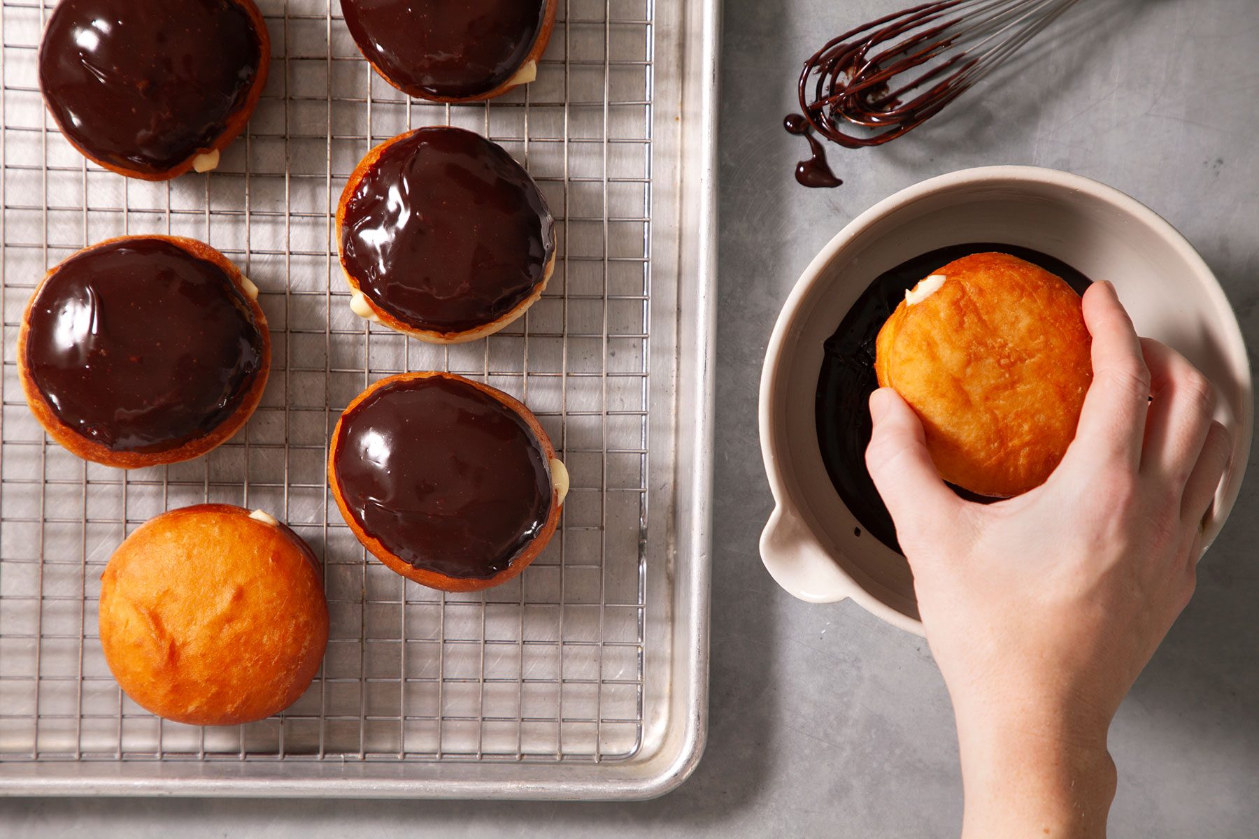 Dipping the doughnuts in melted chocolate