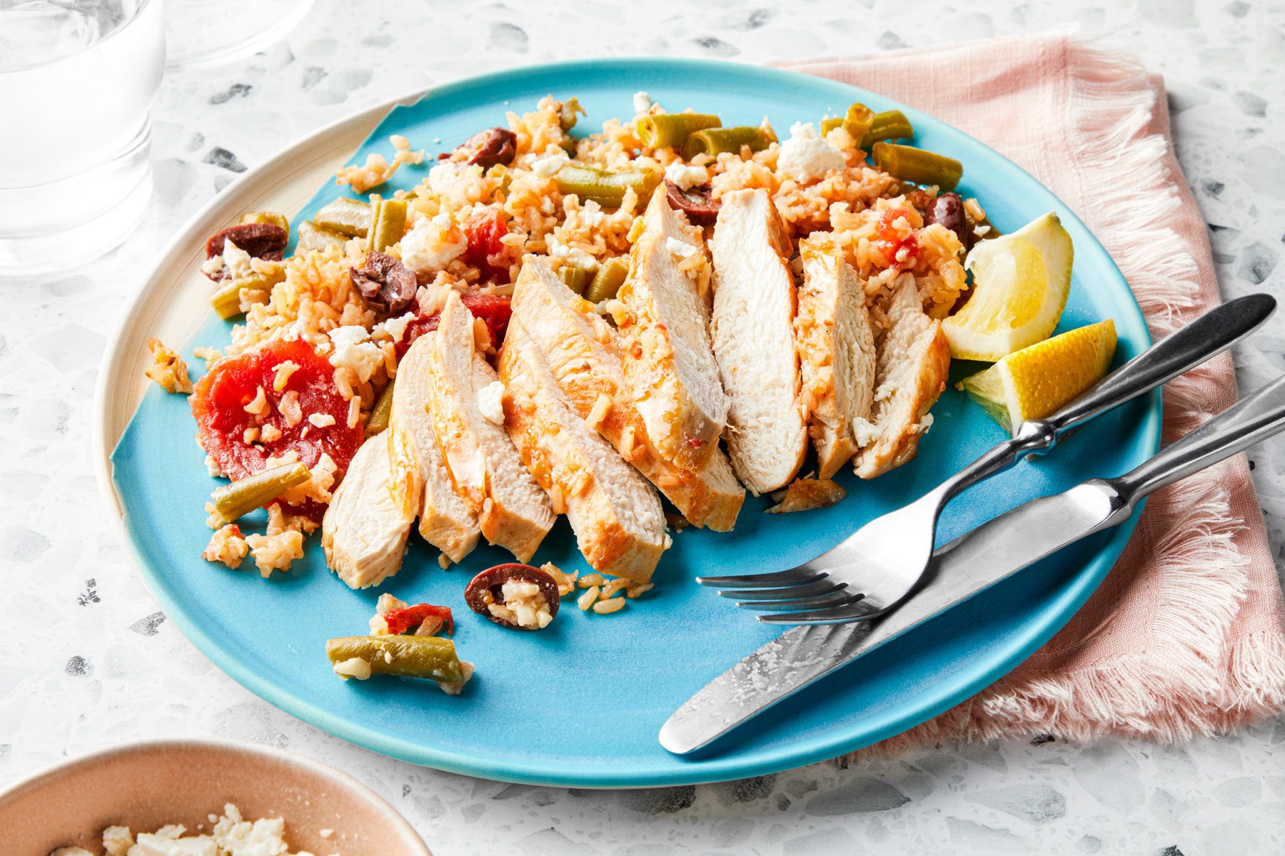 Mediterranean Chicken served in a plate with lemons and forks