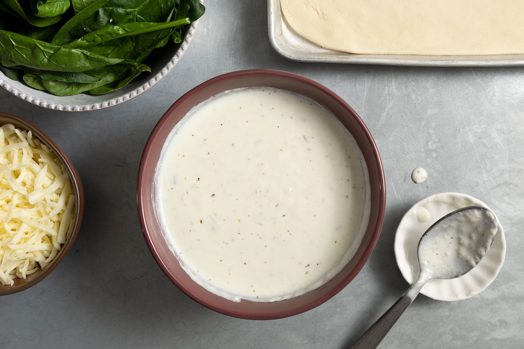 White sauce on table with spoon on the side