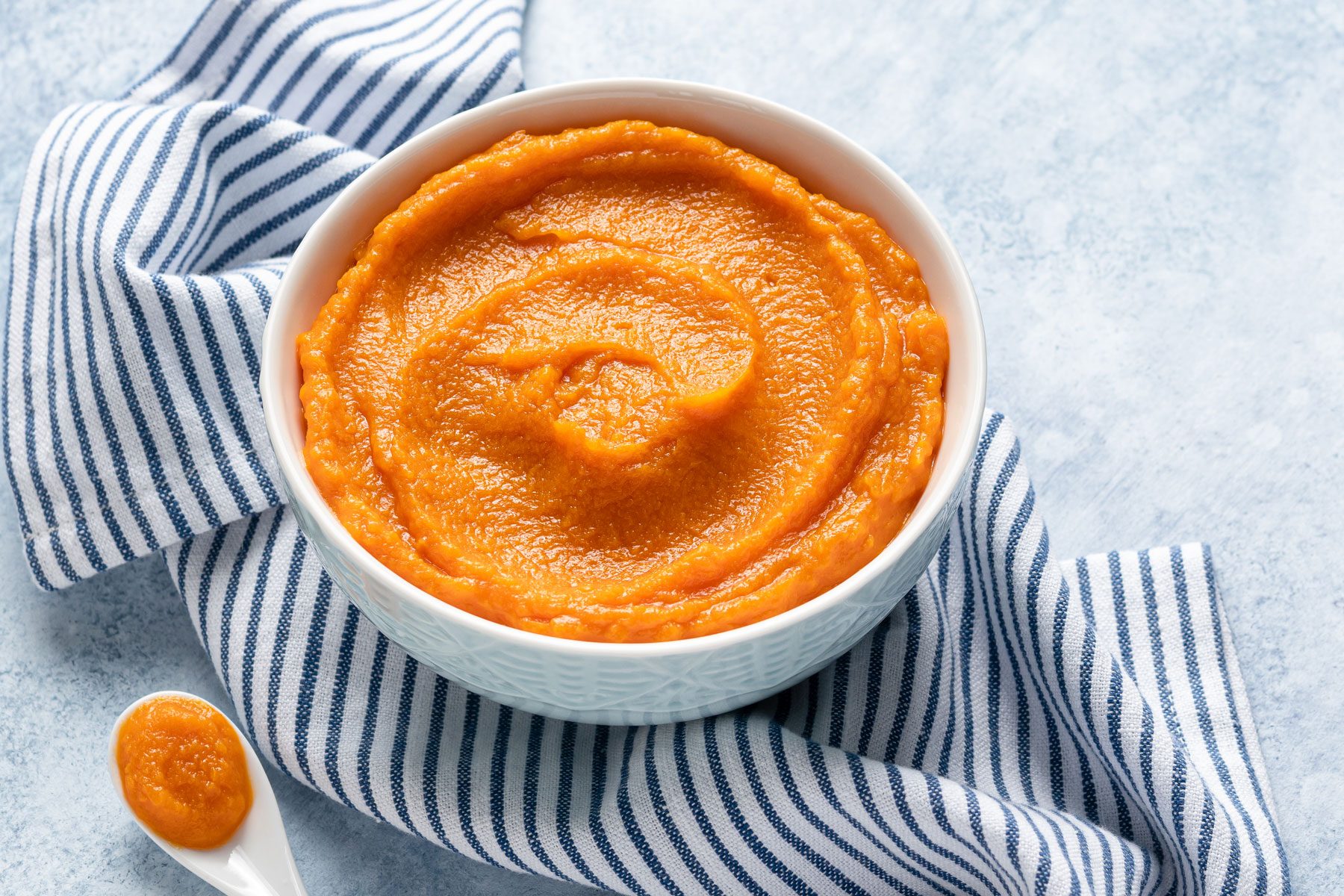 Pumpkin puree i a bowl Blue and white stripes textile