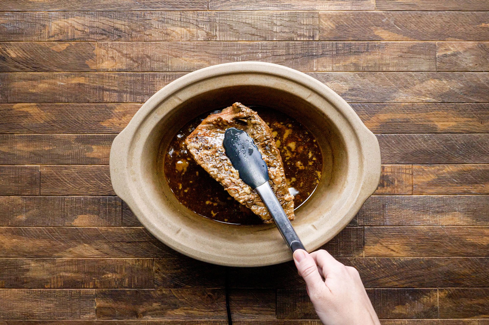 Skim the fat from cooking juices using tongs