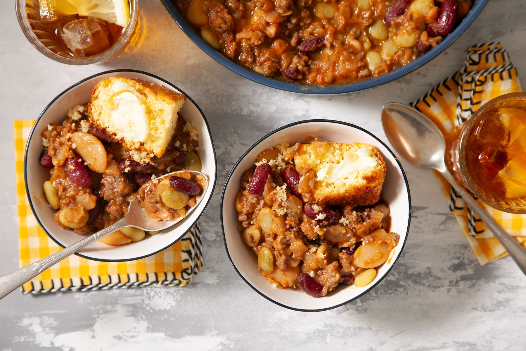 Calico Cowboy Beans and bread served in a small bowl with beverages on side.