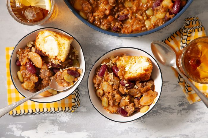 Calico Cowboy Beans and bread served in a small bowl with beverages on side.
