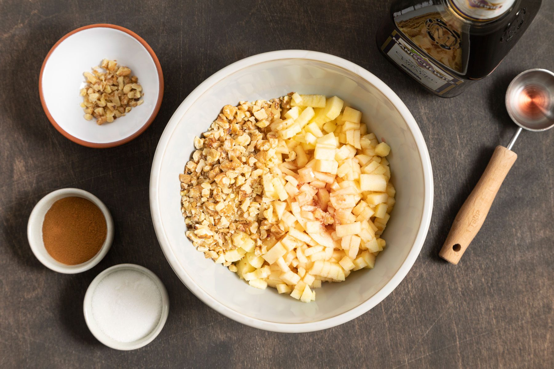 Apple, walnuts and other ingredients to make Charoset placed on a table