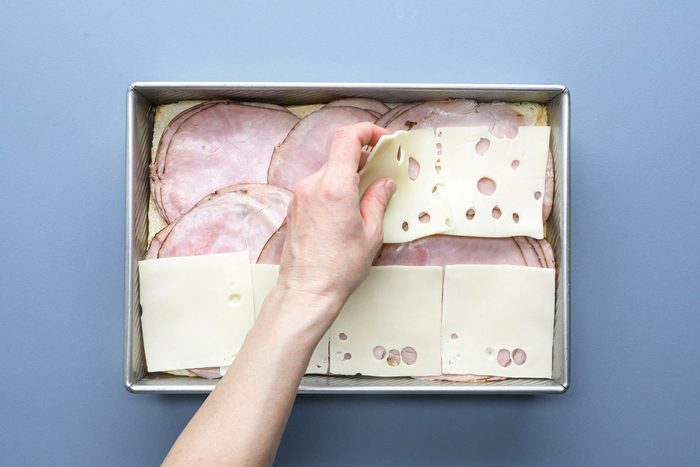 Layering the pan with ham and cheese