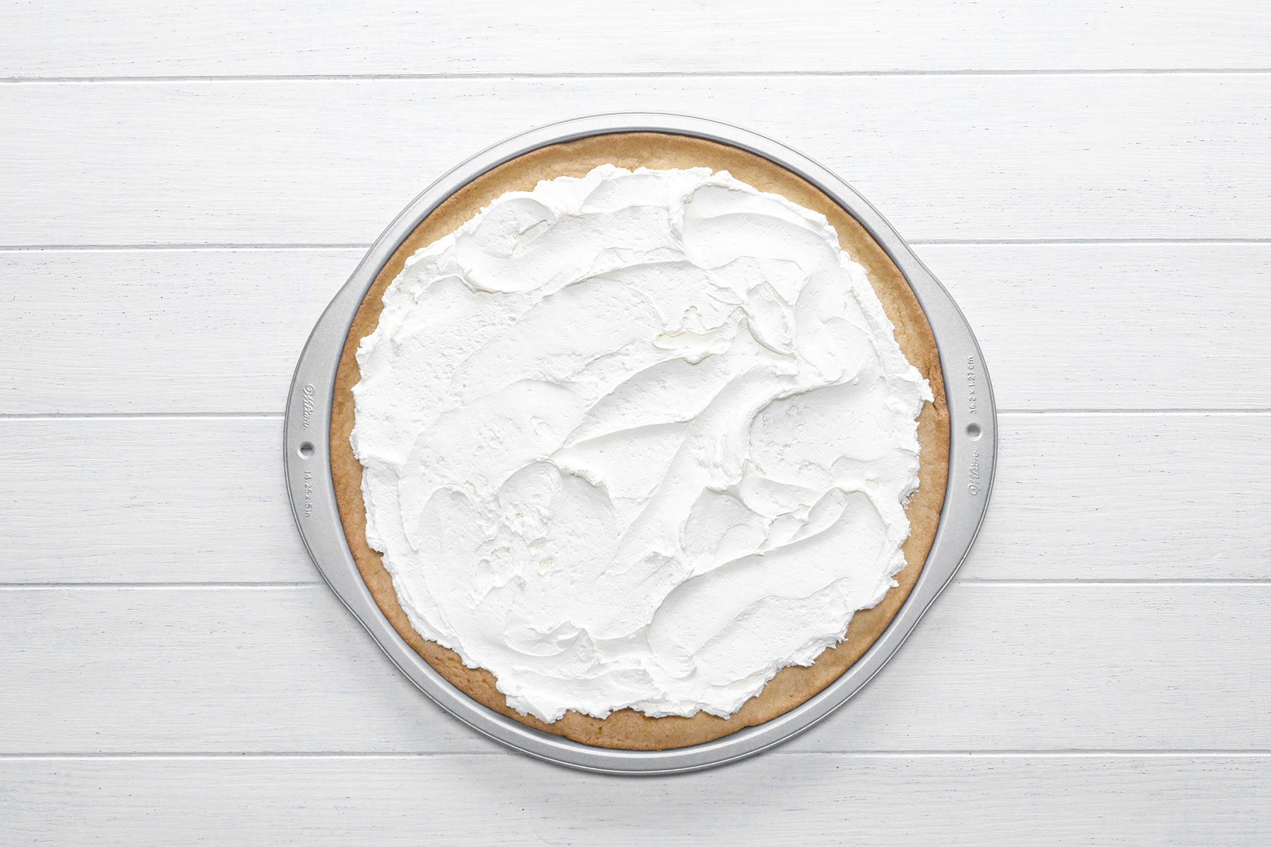 Cream cheese frosting on pizza base 