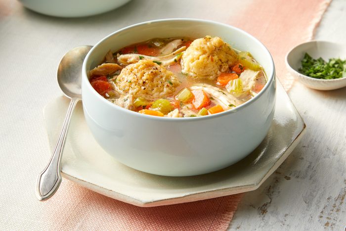 A bowl of matzo ball soup with a spoon