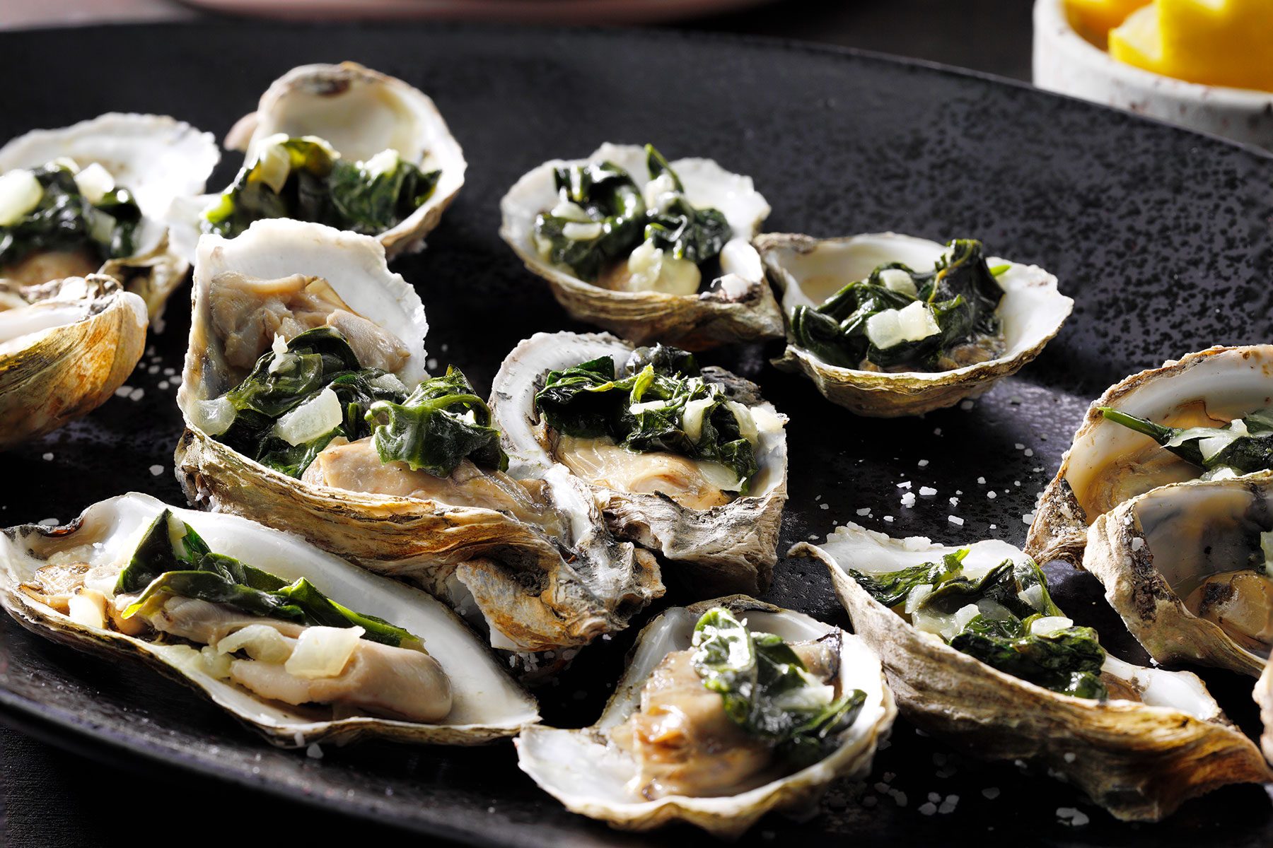 Oysters Rockefeller served in black plate