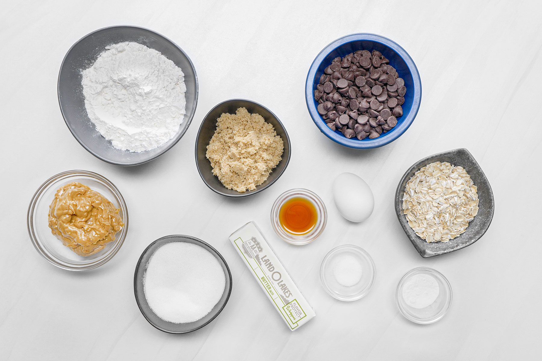Ingredients for Peanut Butter Chocolate Chip Cookies on white surface